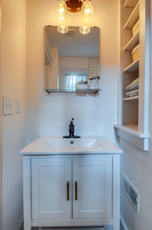 Photo of a small arts and crafts bathroom in Nashville with an integrated sink, shaker cabinets, white cabinets, engineered quartz benchtops, an alcove tub, a shower/bathtub combo, a two-piece toilet, white tile, subway tile, white walls and ceramic floors.