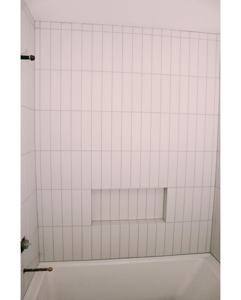 Idee per una piccola stanza da bagno costiera con vasca ad alcova, vasca/doccia, piastrelle beige, piastrelle in gres porcellanato, pavimento in gres porcellanato, pavimento nero, doccia con tenda e nicchia