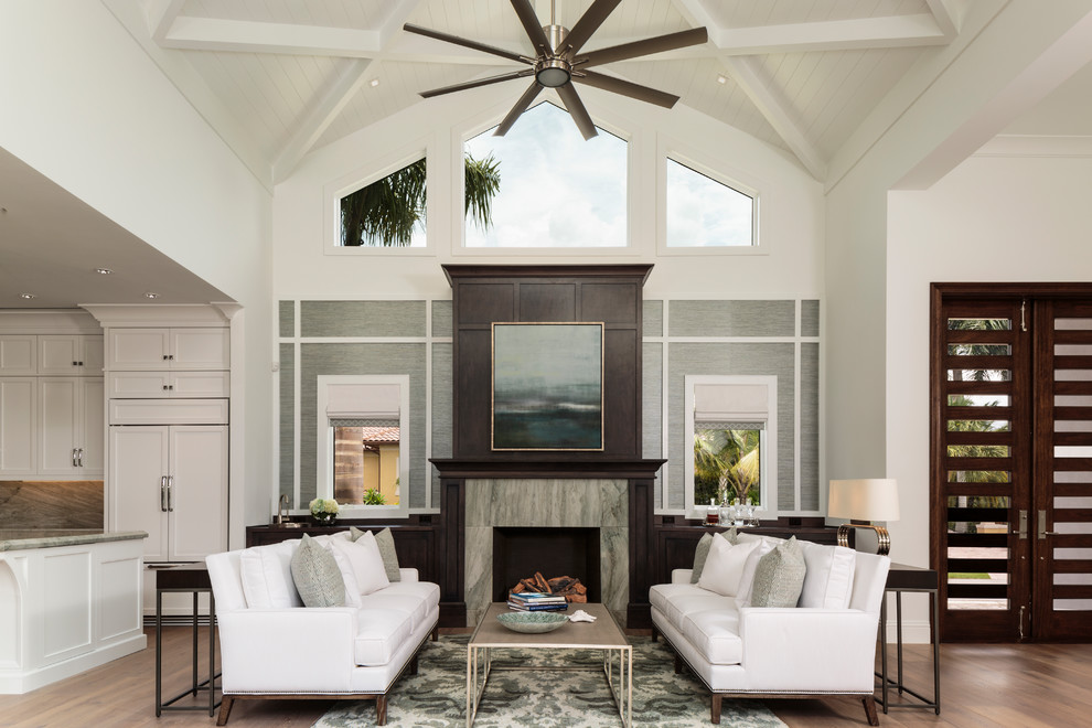 Design ideas for a large transitional formal open concept living room in Miami with white walls, medium hardwood floors, a standard fireplace, a stone fireplace surround, no tv and brown floor.