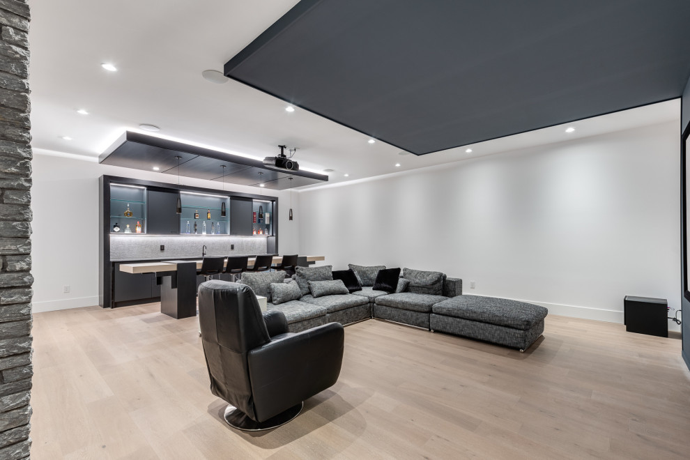 Inspiration for a large contemporary open concept home theatre in Vancouver with white walls, light hardwood floors, a projector screen and beige floor.
