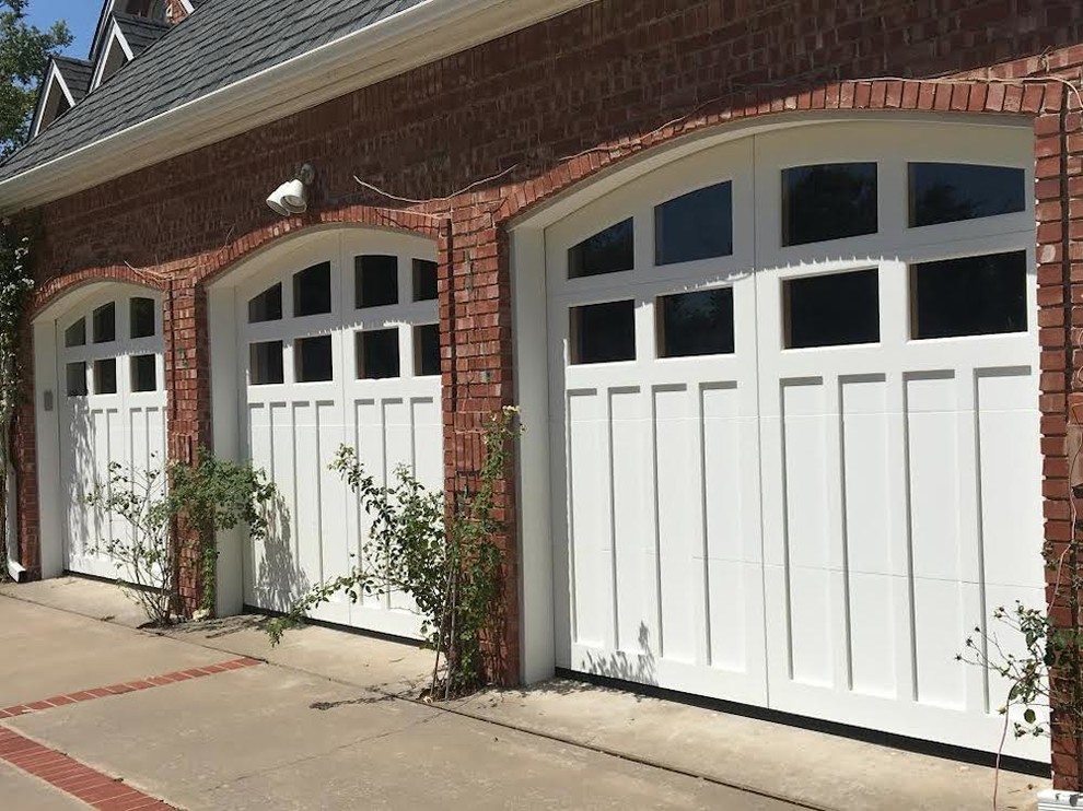 Inspiration for a large traditional attached three-car garage in Oklahoma City.