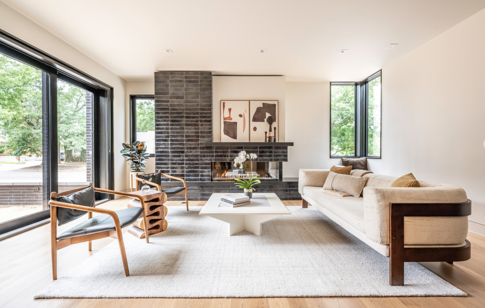 Contemporary living room in Denver with white walls, light hardwood floors, a ribbon fireplace, a brick fireplace surround, no tv and beige floor.