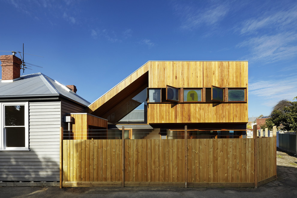 Photo of a contemporary two-storey exterior in Melbourne with wood siding and a flat roof.