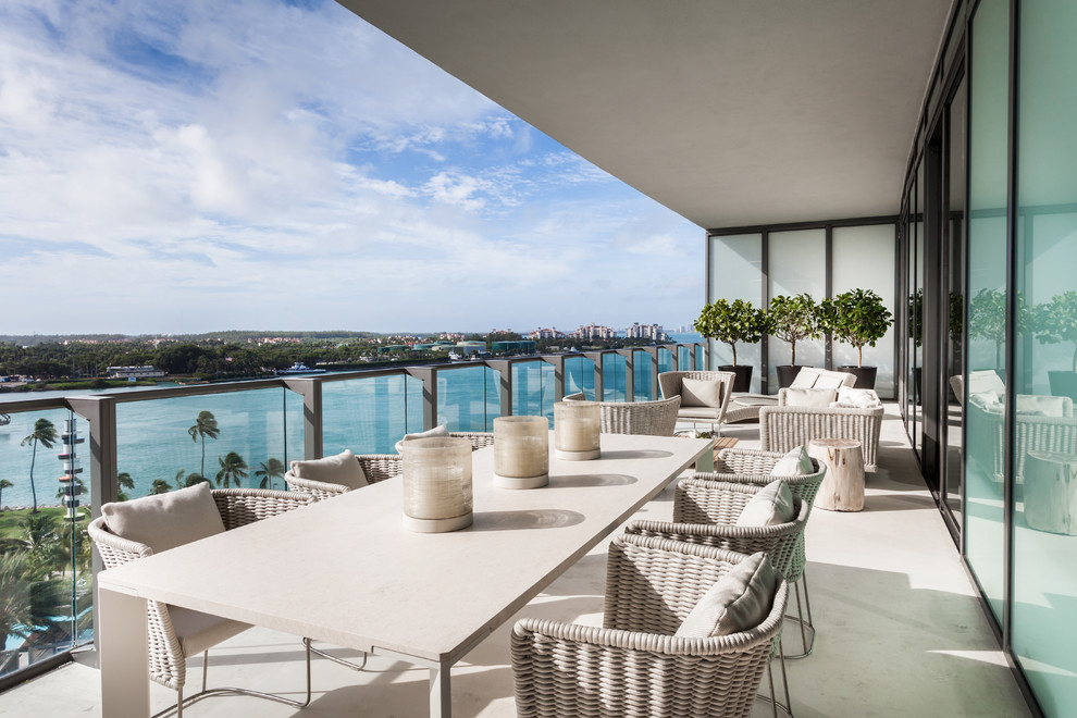 This is an example of a contemporary balcony in Miami with a roof extension.