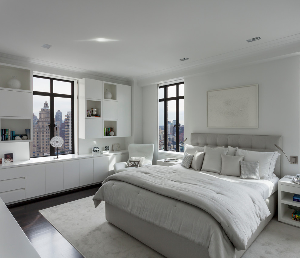 Photo of a large contemporary master bedroom in New York with white walls, dark hardwood floors and no fireplace.