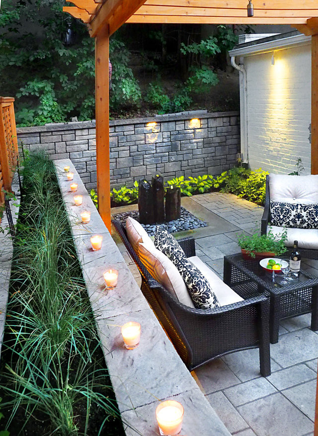 This is an example of a mid-sized contemporary backyard patio in Montreal with a water feature, concrete pavers and a pergola.