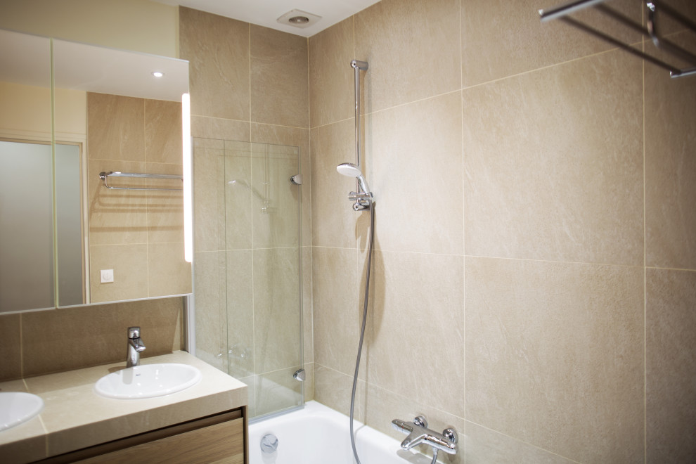 Kleines Klassisches Duschbad mit profilierten Schrankfronten, weißen Schränken, beigen Fliesen, Porzellanfliesen, beiger Wandfarbe, Unterbauwaschbecken, Einzelwaschbecken und schwebendem Waschtisch in Paris