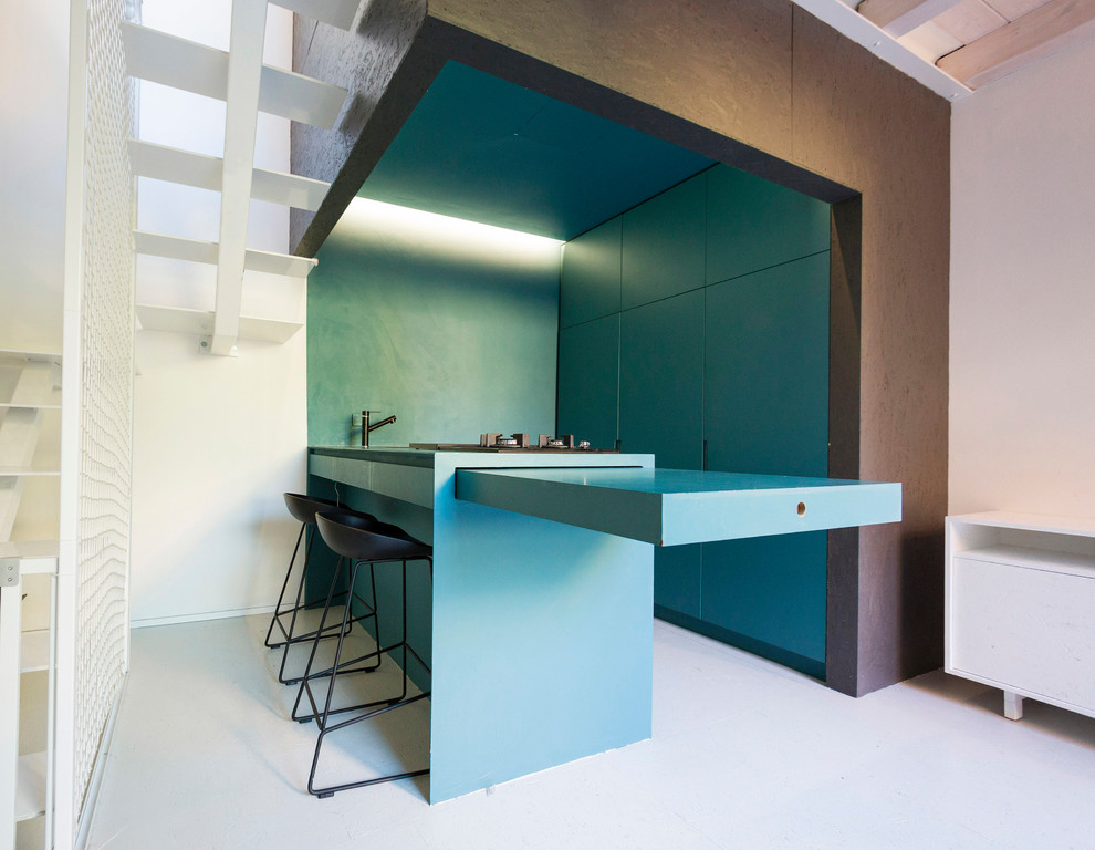 Inspiration for a small contemporary u-shaped open plan kitchen in Bologna with flat-panel cabinets, blue cabinets, panelled appliances, a peninsula, blue benchtop, a single-bowl sink, wood benchtops and grey floor.