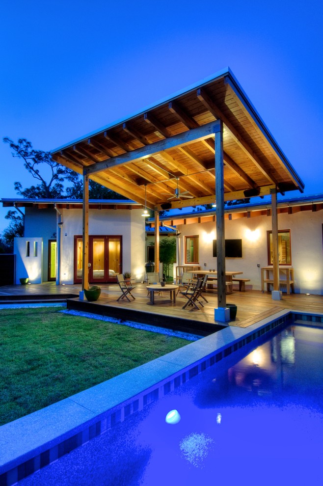 Inspiration for a large country backyard rectangular lap pool in Other with decking.