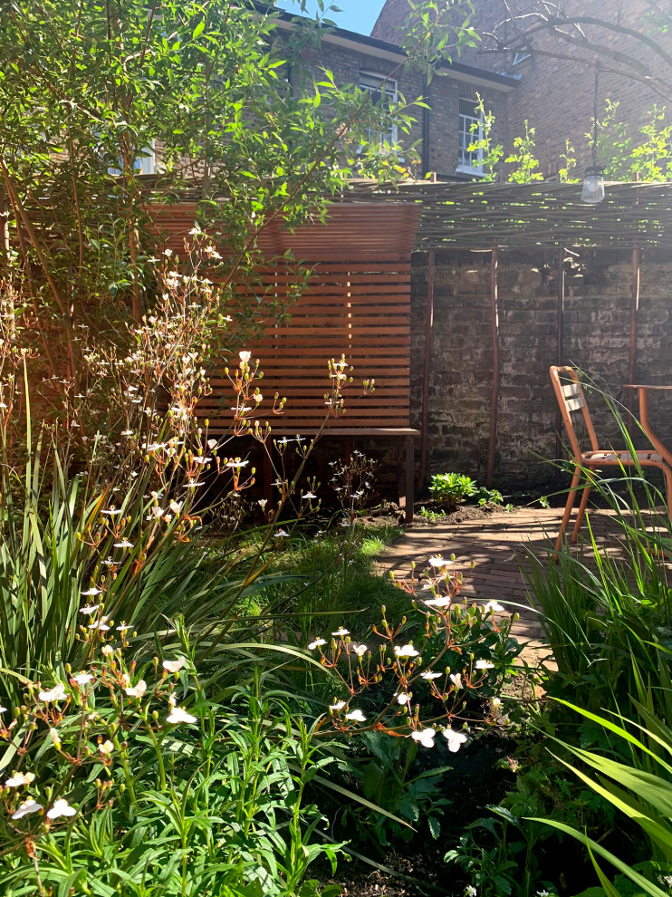 Immagine di un giardino eclettico esposto in pieno sole con recinzione in legno