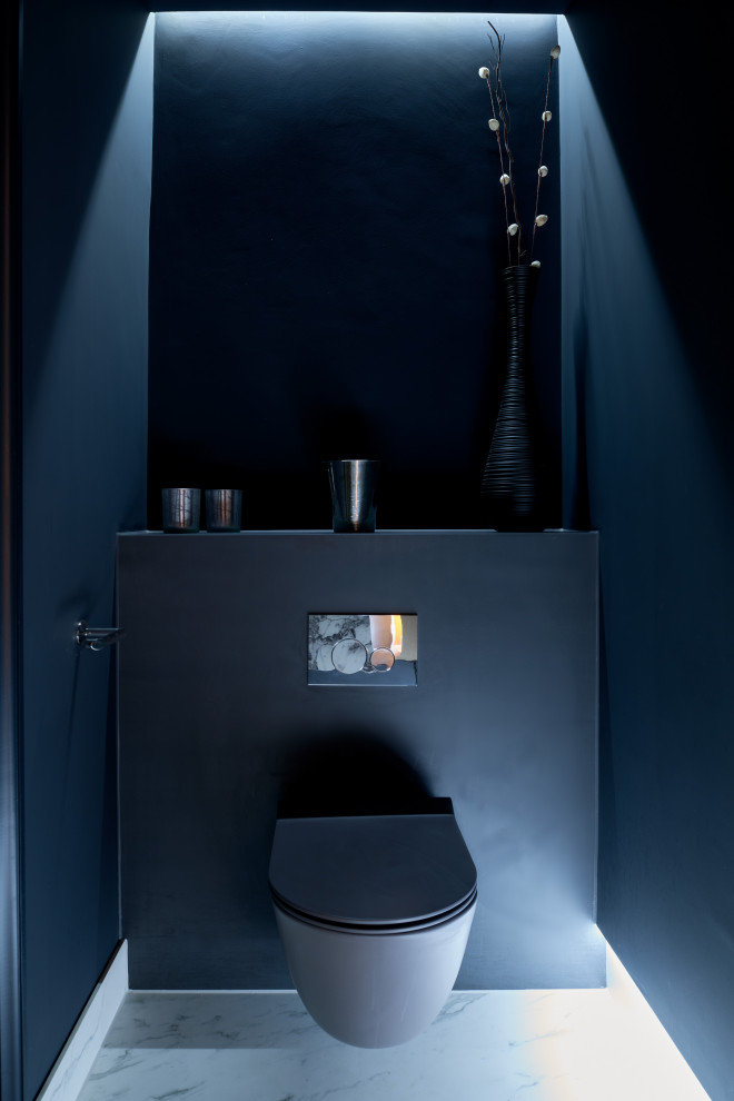Inspiration for a small modern cloakroom in Other with a wall mounted toilet, blue walls, ceramic flooring, white floors and feature lighting.