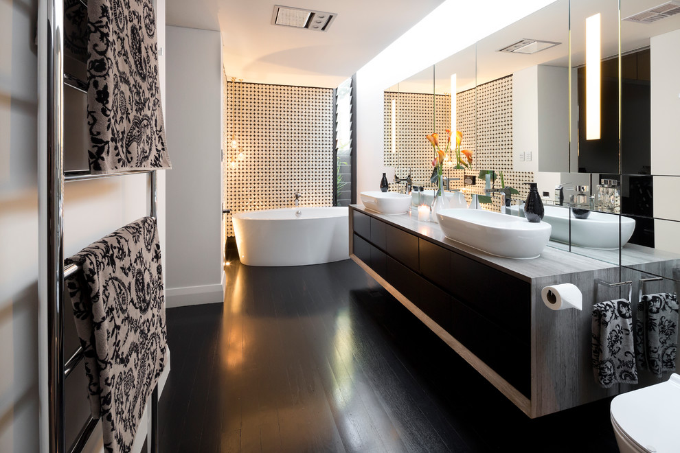 This is an example of a contemporary master bathroom in Perth with flat-panel cabinets, distressed cabinets, a freestanding tub, a one-piece toilet, white walls, dark hardwood floors, a vessel sink and wood benchtops.