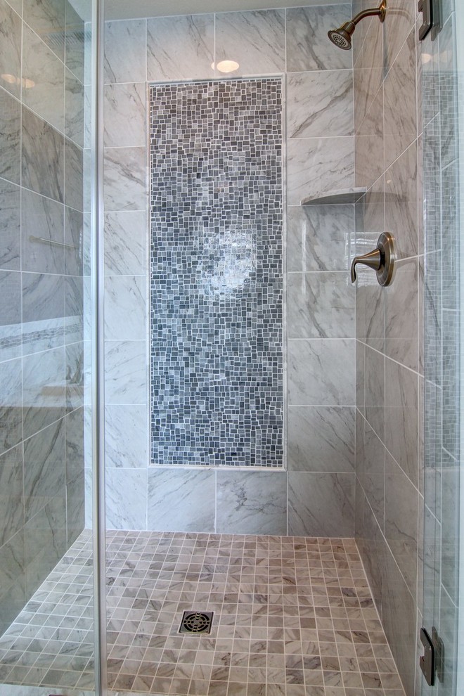 Inspiration for a mid-sized beach style master bathroom in Other with recessed-panel cabinets, dark wood cabinets, a drop-in tub, an alcove shower, gray tile, stone tile, grey walls, marble floors, an undermount sink and marble benchtops.