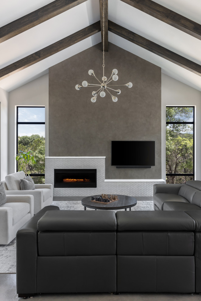 Cette image montre un salon design ouvert avec sol en béton ciré, un manteau de cheminée en carrelage et poutres apparentes.