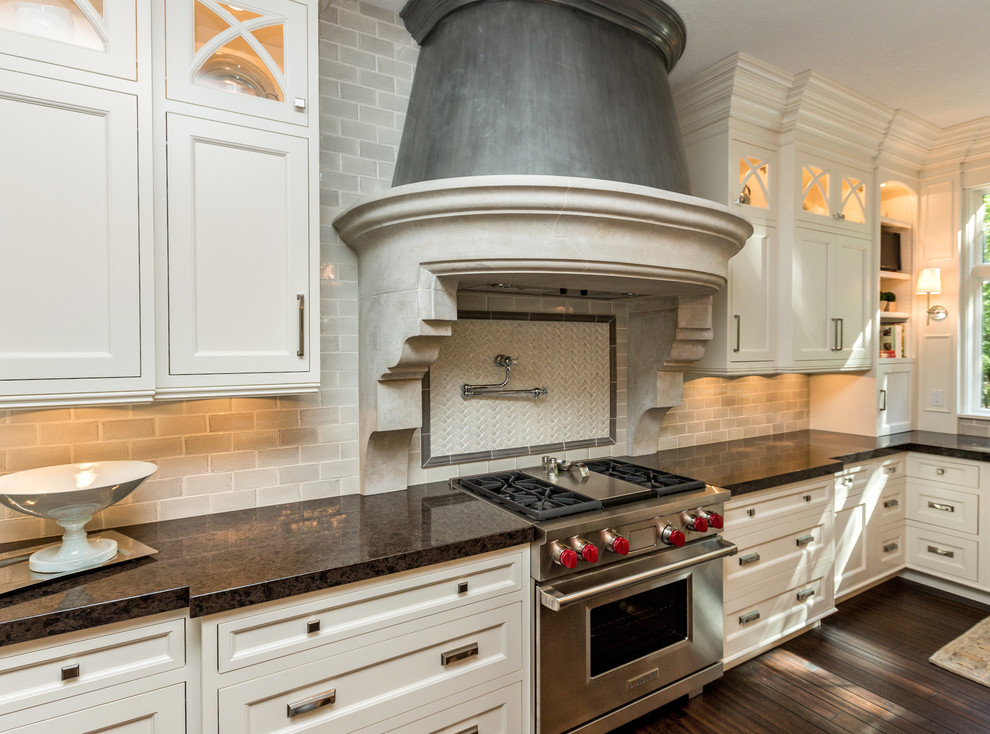 Inspiration for a large transitional u-shaped dark wood floor eat-in kitchen remodel with a farmhouse sink, shaker cabinets, white cabinets, marble countertops, gray backsplash, subway tile backsplash, stainless steel appliances and two islands