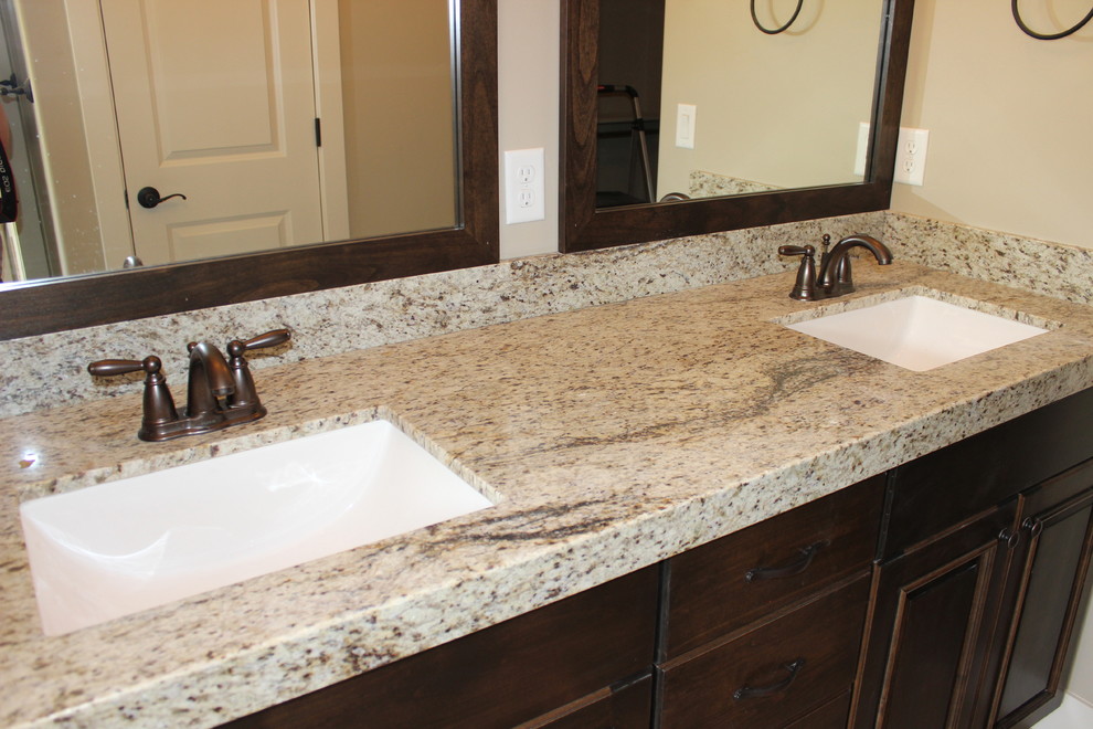This is an example of a large traditional master bathroom in Salt Lake City with an undermount sink, raised-panel cabinets, dark wood cabinets, granite benchtops, a corner tub, an open shower, a two-piece toilet, beige tile, ceramic tile, beige walls and ceramic floors.