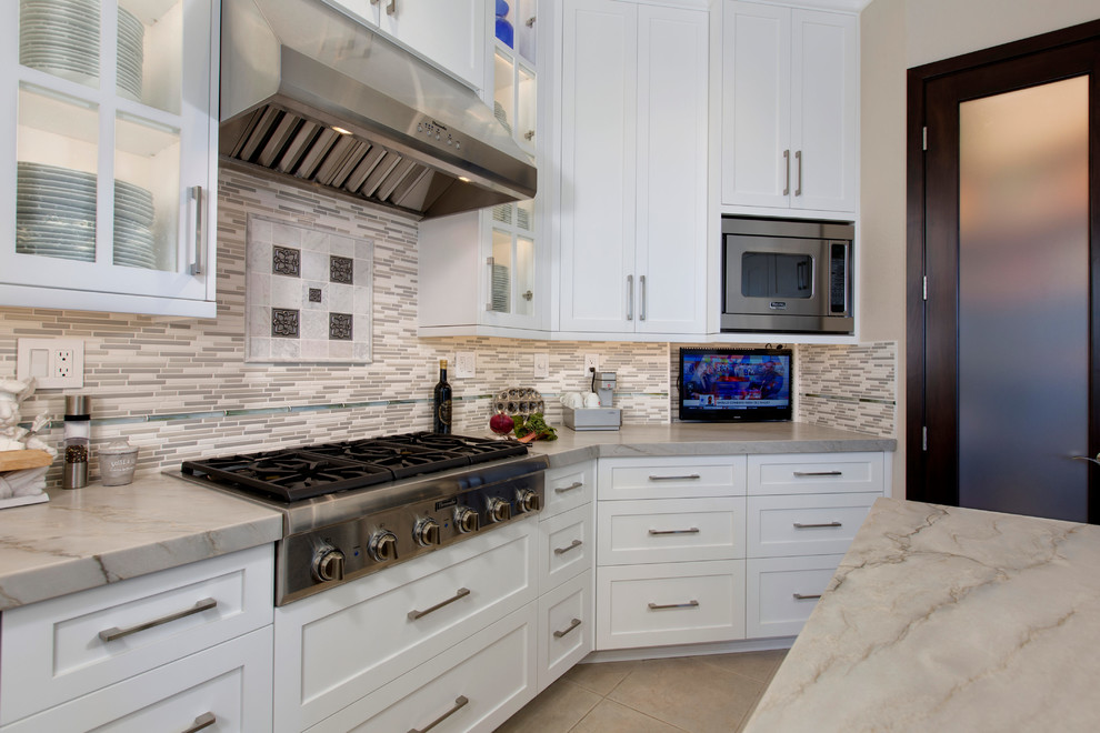Design ideas for a mid-sized transitional u-shaped kitchen pantry in San Diego with an undermount sink, recessed-panel cabinets, white cabinets, quartzite benchtops, grey splashback, ceramic splashback, stainless steel appliances, porcelain floors and with island.