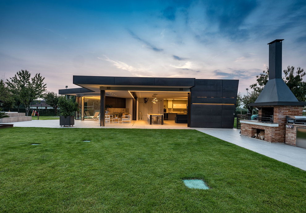 Photo of a large contemporary one-storey black exterior with metal siding and a flat roof.
