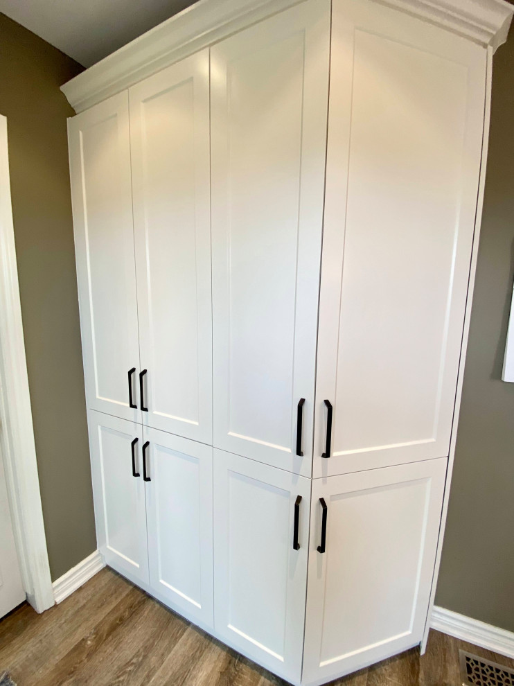 Example of a mid-sized transitional l-shaped enclosed kitchen design with a double-bowl sink, recessed-panel cabinets, white cabinets, gray backsplash, glass tile backsplash and no island