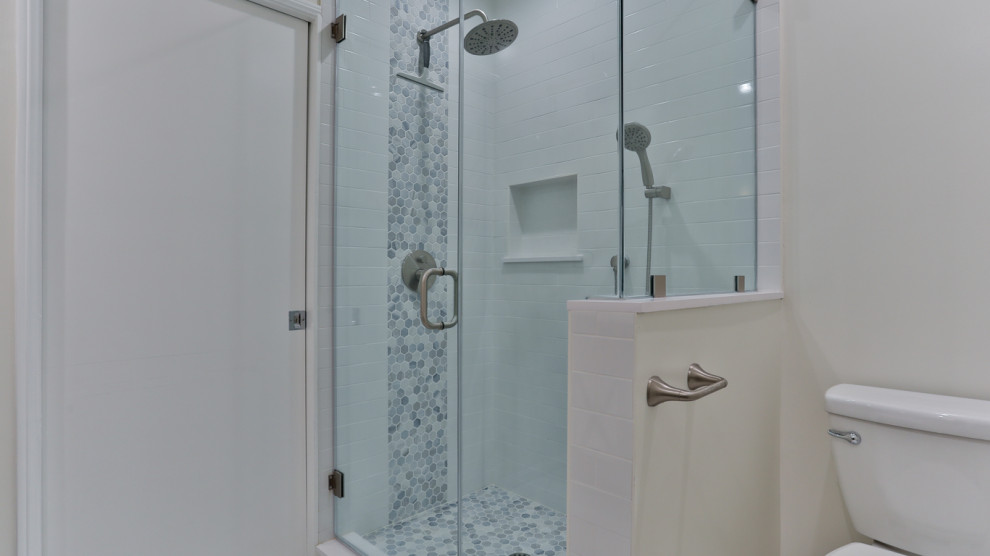 Design ideas for a medium sized modern ensuite bathroom in Los Angeles with shaker cabinets, green cabinets, a corner shower, a one-piece toilet, white tiles, ceramic tiles, beige walls, mosaic tile flooring, a built-in sink, marble worktops, white floors, a hinged door, white worktops, a single sink, a built in vanity unit and wainscoting.