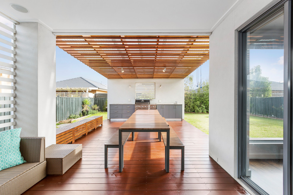 Large contemporary backyard patio in Melbourne with an outdoor kitchen and a pergola.