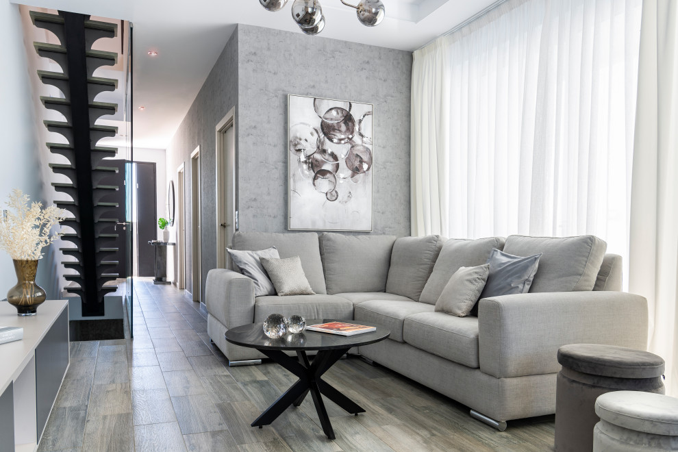 This is an example of a large contemporary living room in Seville with ceramic floors, a wall-mounted tv, grey floor, wallpaper and grey walls.