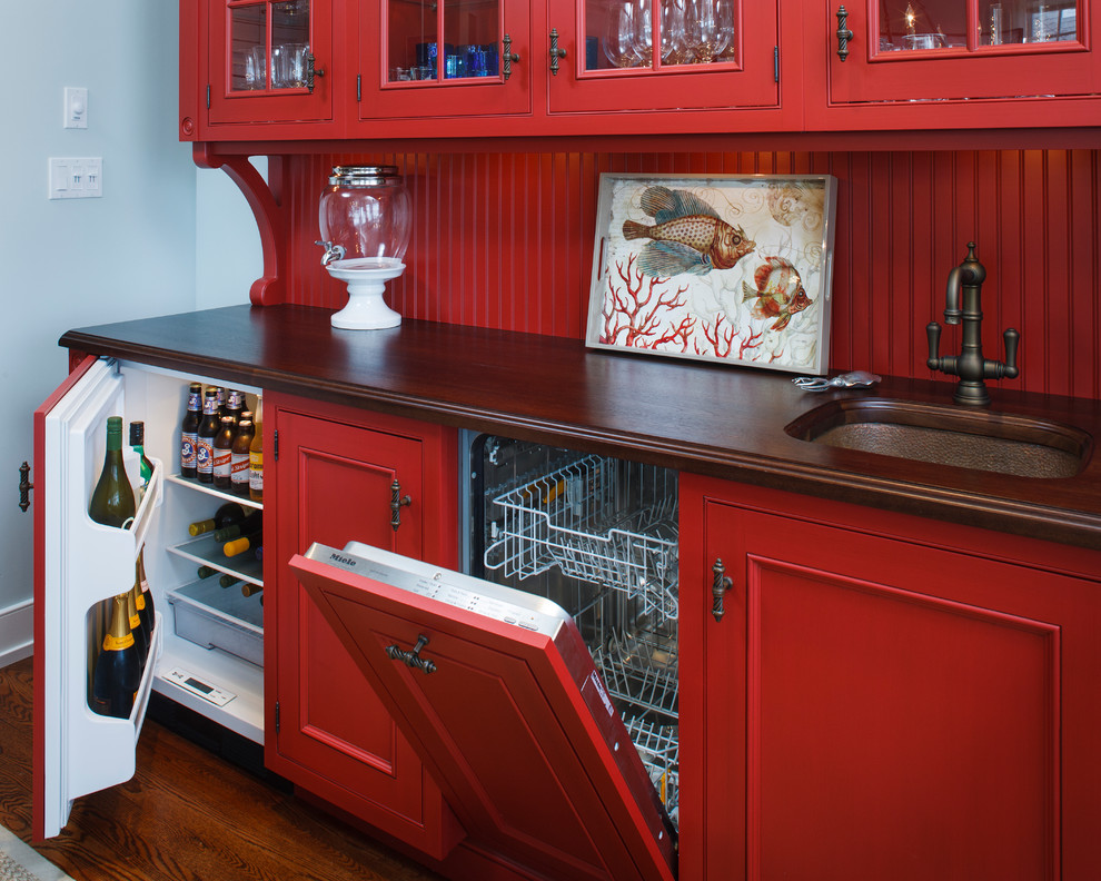 Design ideas for a beach style kitchen in New York with an undermount sink, recessed-panel cabinets, red cabinets, wood benchtops, red splashback and panelled appliances.