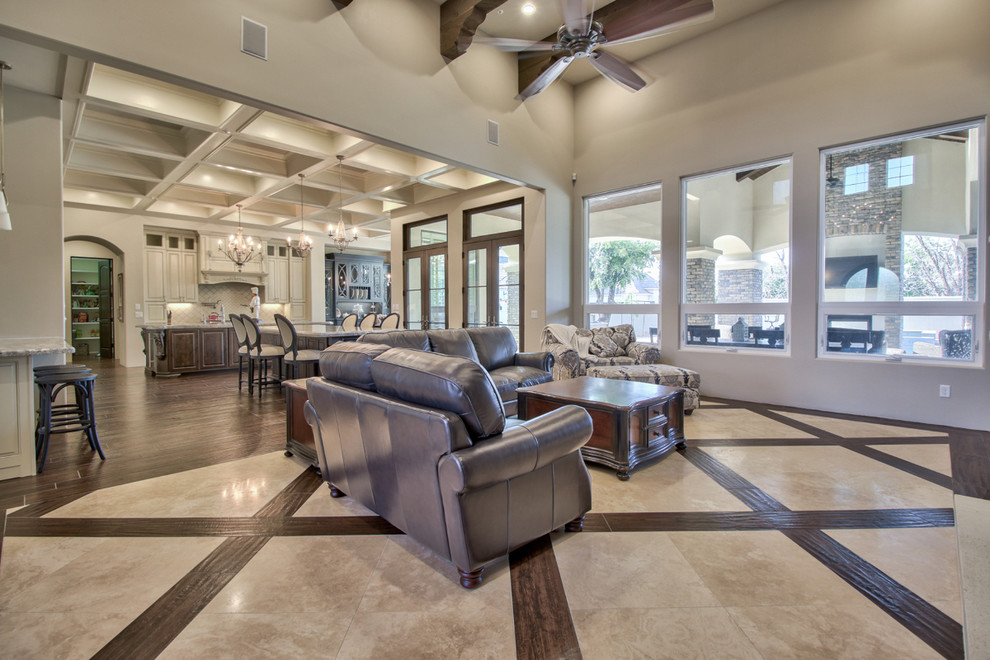 Large traditional open concept family room in Phoenix with grey walls, marble floors, a standard fireplace, a stone fireplace surround, a wall-mounted tv and beige floor.