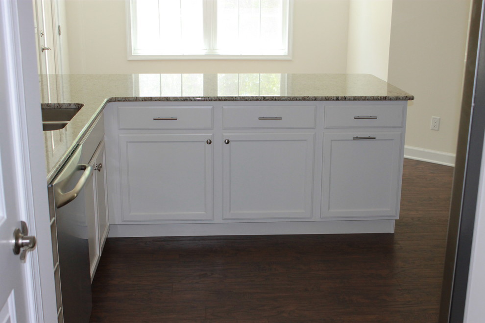 Inspiration for a mid-sized transitional u-shaped dark wood floor eat-in kitchen remodel with a double-bowl sink, shaker cabinets, white cabinets, granite countertops, black backsplash, ceramic backsplash, stainless steel appliances and an island