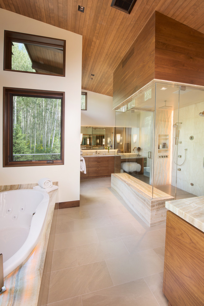 Photo of an expansive contemporary master bathroom in Denver with flat-panel cabinets, medium wood cabinets, an alcove tub, beige tile, beige walls, marble floors, an undermount sink, marble benchtops and an alcove shower.