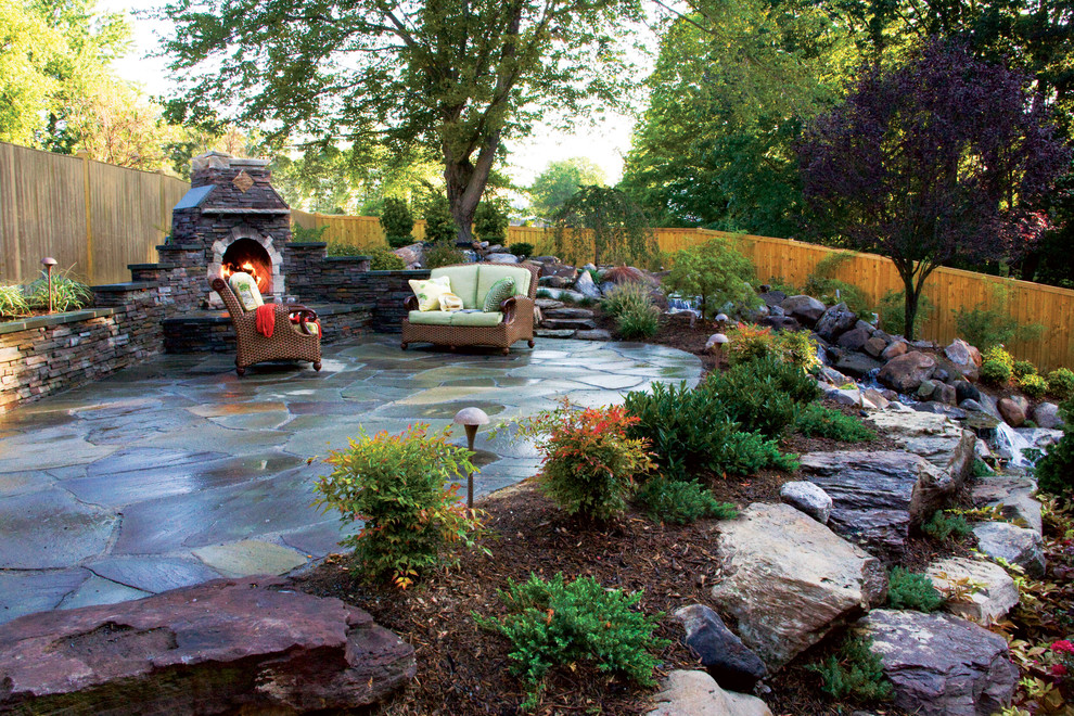 Inspiration for a large traditional backyard full sun garden for summer in DC Metro with a water feature and natural stone pavers.