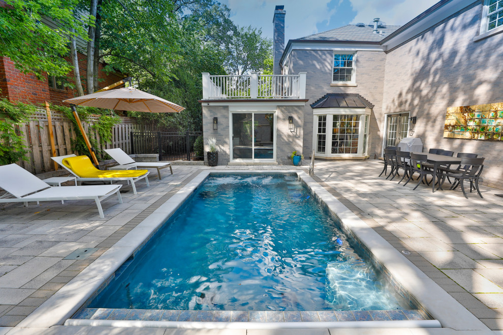 Foto de casa de la piscina y piscina alargada clásica pequeña rectangular en patio trasero con adoquines de hormigón