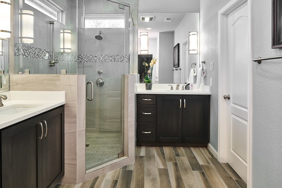 Transitional master beige tile and porcelain tile porcelain tile corner shower photo in Austin with shaker cabinets, dark wood cabinets, gray walls, an undermount sink, quartz countertops and a hinged shower door