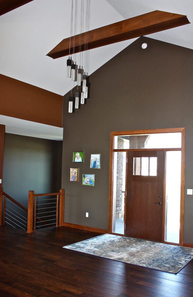 Example of a large transitional medium tone wood floor and brown floor foyer design with brown walls and a brown front door
