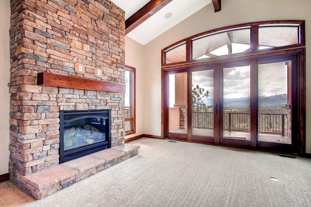 Inspiration for a mid-sized arts and crafts open concept living room in Denver with carpet, a standard fireplace, a stone fireplace surround and a wall-mounted tv.