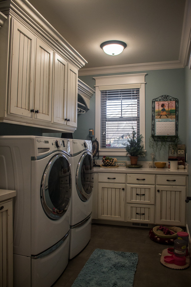 Design ideas for a mid-sized traditional u-shaped dedicated laundry room in Salt Lake City with an undermount sink, recessed-panel cabinets, distressed cabinets, quartz benchtops, blue walls, ceramic floors and a side-by-side washer and dryer.