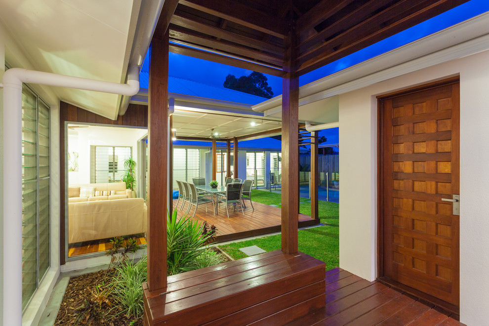 This is an example of a modern entryway in Sunshine Coast with white walls, a pivot front door and a medium wood front door.
