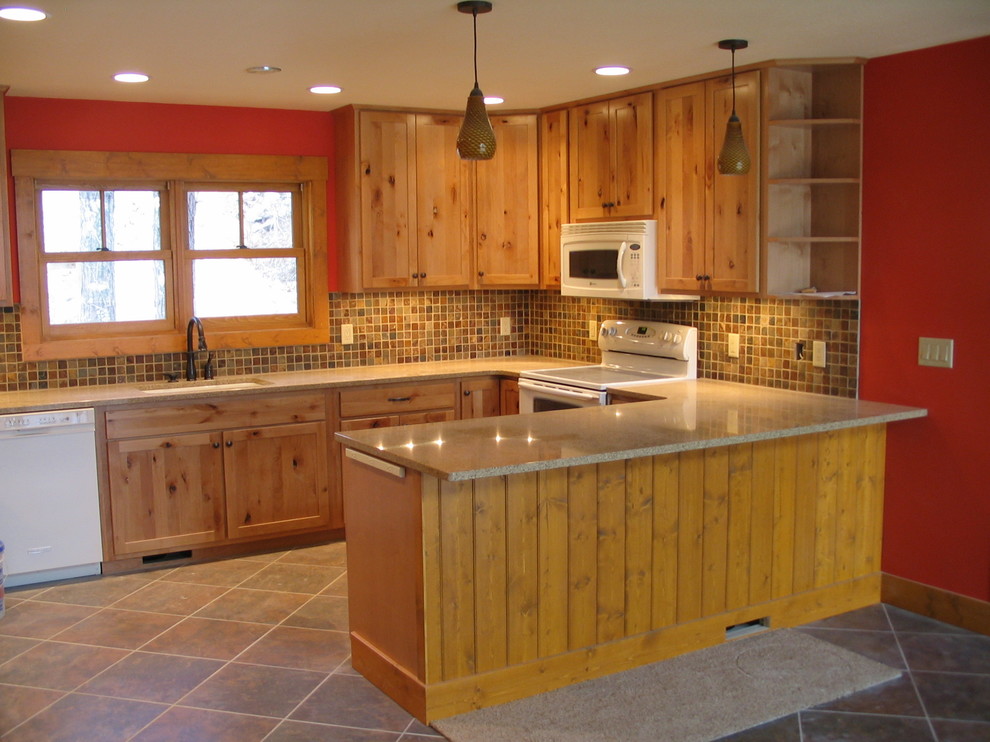 Mid-sized mountain style u-shaped porcelain tile and beige floor enclosed kitchen photo with an undermount sink, recessed-panel cabinets, light wood cabinets, quartz countertops, beige backsplash, porcelain backsplash, white appliances and a peninsula