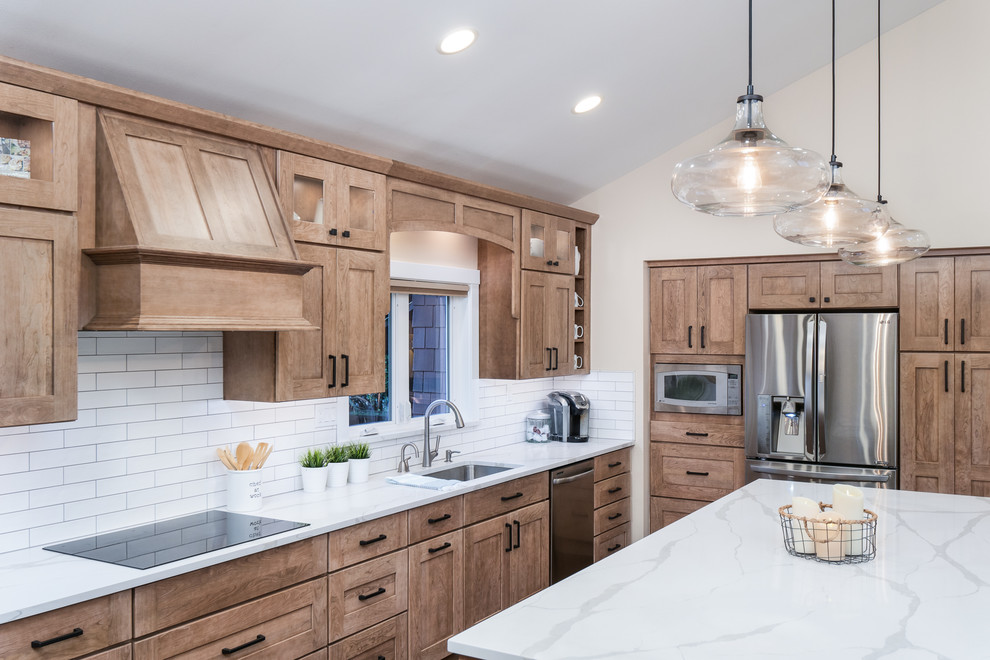 Example of a large transitional l-shaped medium tone wood floor and brown floor open concept kitchen design in Seattle with an undermount sink, shaker cabinets, light wood cabinets, quartz countertops, white backsplash, porcelain backsplash, stainless steel appliances, an island and white countertops