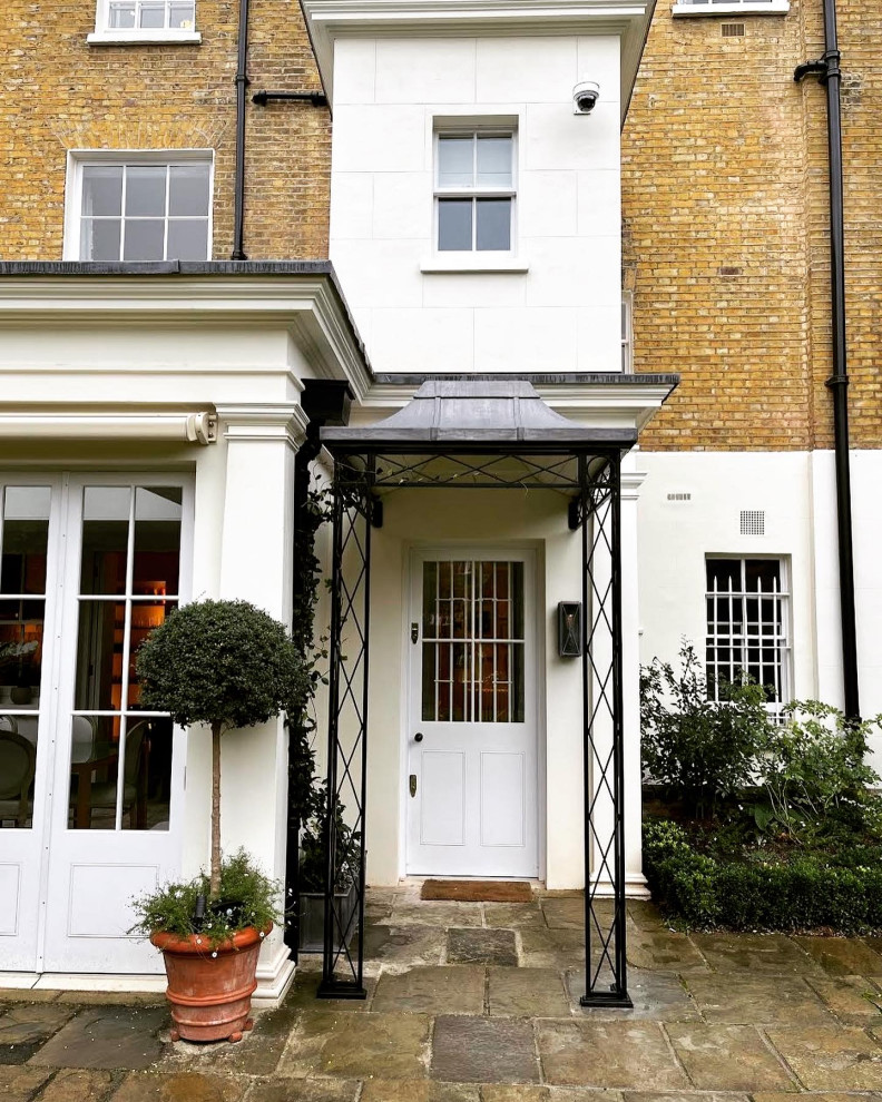 This is an example of a mid-sized traditional entryway in London with a single front door and a white front door.
