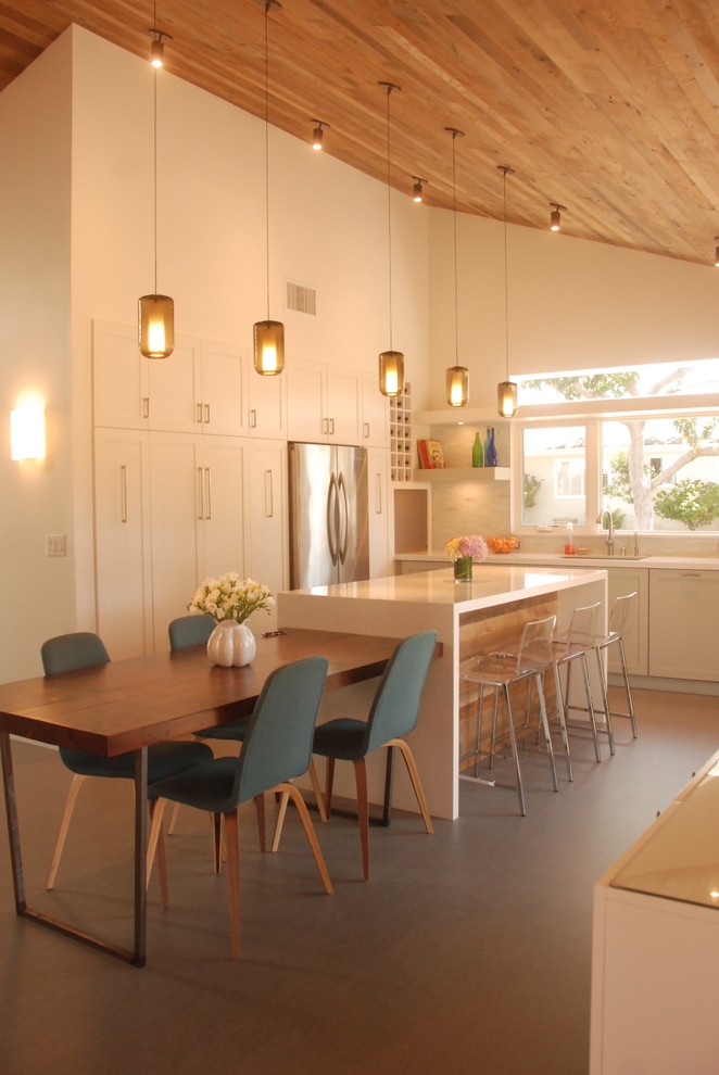 Photo of a country l-shaped eat-in kitchen in Los Angeles with an undermount sink, shaker cabinets, white cabinets, white splashback, stainless steel appliances and with island.