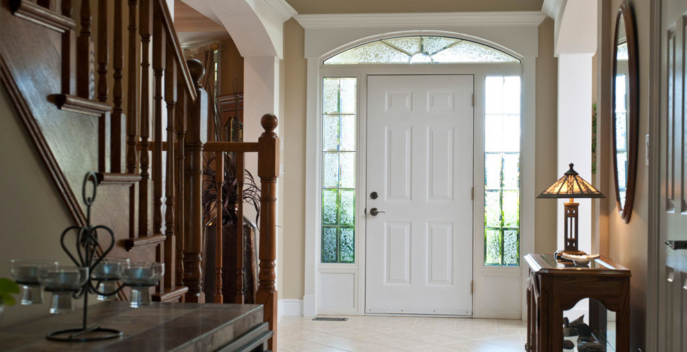 This is an example of a mid-sized traditional foyer in Toronto with white walls, porcelain floors, a single front door and a white front door.