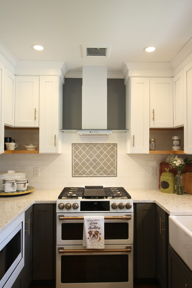 Inspiration for a mid-sized transitional u-shaped medium tone wood floor and brown floor enclosed kitchen remodel with a farmhouse sink, shaker cabinets, white cabinets, quartz countertops, white backsplash, subway tile backsplash, white appliances, no island and beige countertops