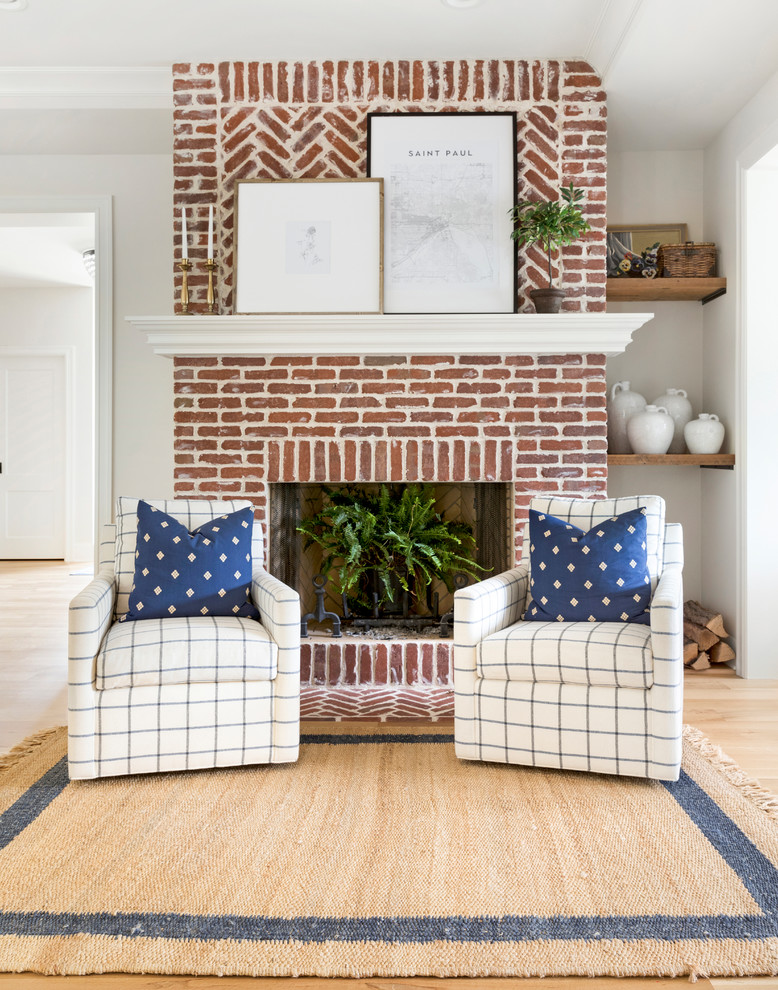 Inspiration for a mid-sized beach style enclosed living room in Minneapolis with light hardwood floors, a standard fireplace and a brick fireplace surround.
