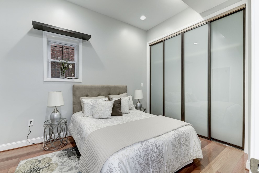 Small transitional guest bedroom in DC Metro with white walls, light hardwood floors, beige floor and no fireplace.
