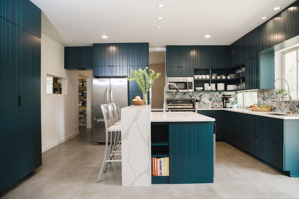 Inspiration for a mid-sized contemporary l-shaped open plan kitchen in Austin with an undermount sink, flat-panel cabinets, blue cabinets, quartz benchtops, multi-coloured splashback, cement tile splashback, stainless steel appliances, cement tiles, with island, grey floor and white benchtop.