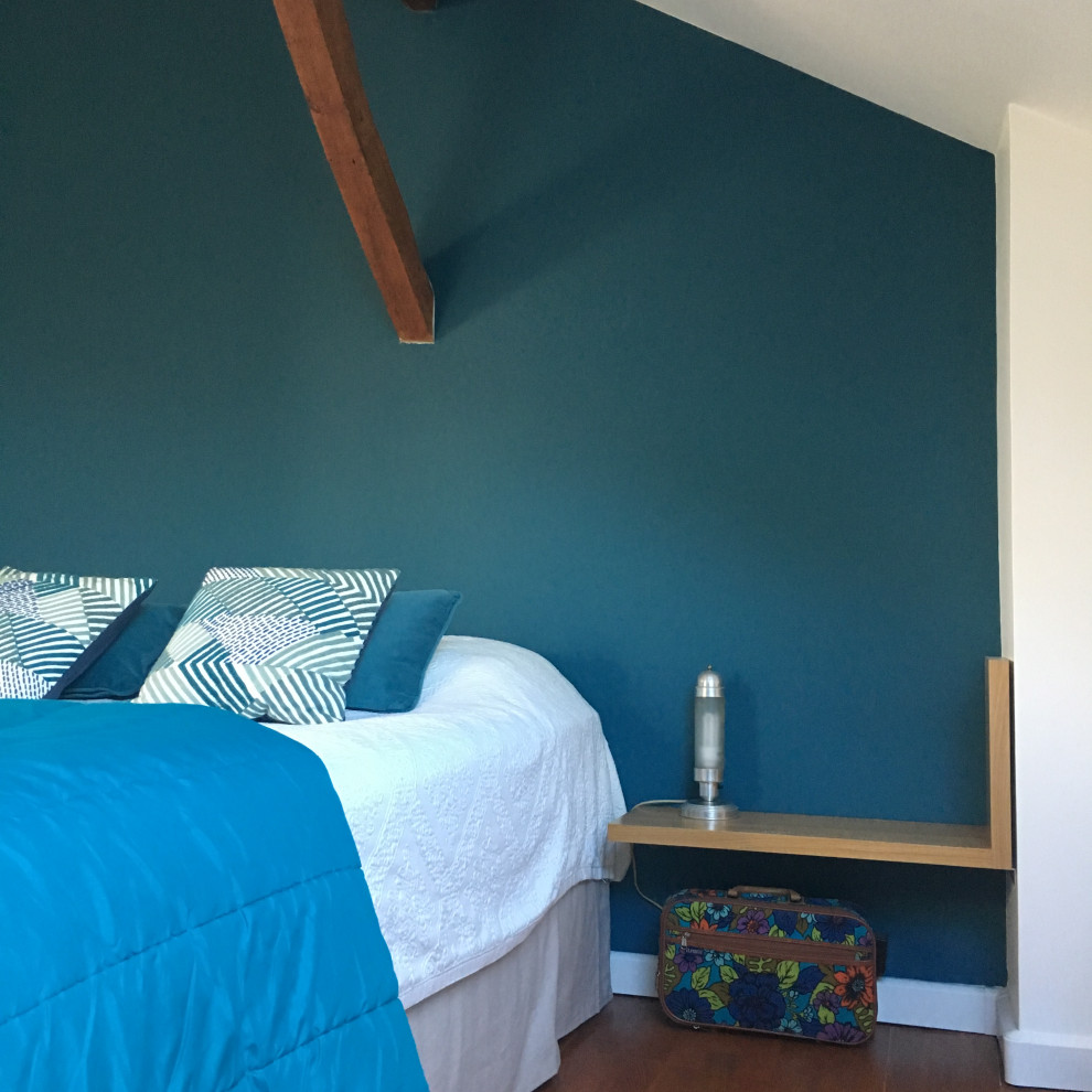 Imagen de dormitorio principal moderno grande con paredes azules, suelo marrón y vigas vistas