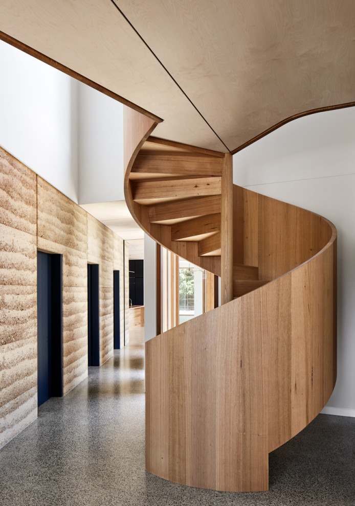 Cette image montre un grand escalier hélicoïdal design en bois avec des marches en bois et des contremarches en bois.
