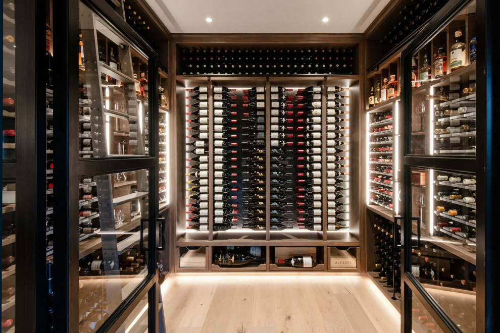 Photo of a country wine cellar in Portland with light hardwood floors and storage racks.
