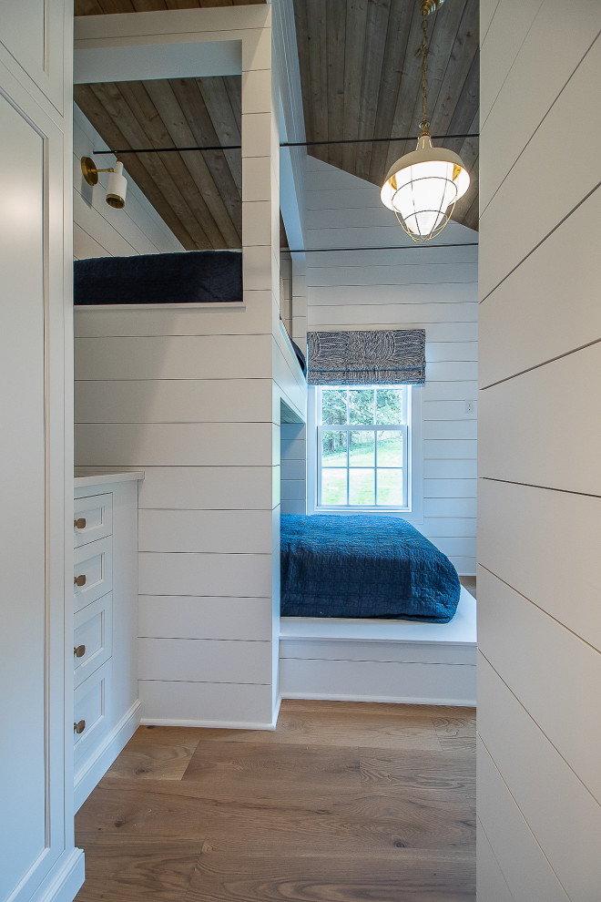 クリーブランドにある中くらいなトラディショナルスタイルのおしゃれな客用寝室 (白い壁、無垢フローリング、茶色い床、板張り天井、塗装板張りの壁)